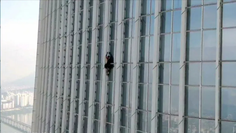 بالفيديو: دون حبال.. متسلق يغامر بحياته لتسلق برج عملاق